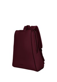 Sac à dos bordeaux avec une texture lisse, de forme rectangulaire, avec des bretelles rembourrées et des accents noirs le long de la fermeture éclair et des bords.