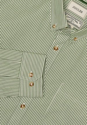 Zielona i biała w paski koszula z guzikami, wykonana z pranej popeliny. Posiada perłowe guziki i naszywaną kieszeń po lewej stronie.