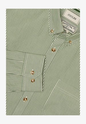 Zielona i biała w paski koszula z guzikami, wykonana z pranej popeliny. Posiada perłowe guziki i naszywaną kieszeń po lewej stronie.