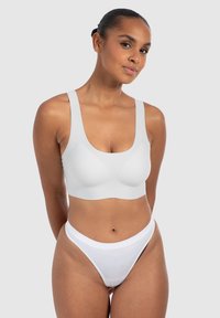 Witte naadloze bh met brede bandjes en een ronde halslijn, ontworpen voor comfort. Gecombineerd met een bijpassende witte high-waisted string.