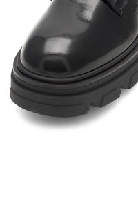 Pantof knaptor de piele lucioasă neagră, cu o talpă groasă din cauciuc texturat și vârf rotund. Dispune de un midsole stratificat pentru înălțime și stabilitate suplimentară.