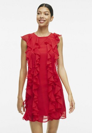 Vestido rojo sin mangas con tela transparente y detalles de volantes en la parte delantera, que resaltan un ajuste holgado y un diseño a la altura de la rodilla.