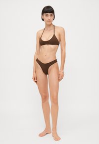 Braunes Bikini-Set mit einem Triangel-Oberteil und dünnen Trägern sowie hochgeschnittenen Unterteilen. Glatte Textur mit minimalistischem Design.