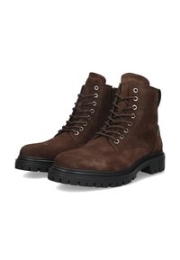 Botas de tobillo de ante marrón con una suela de goma negra resistente, punta redonda y ojales metálicos para los cordones. Textura suave con un talón reforzado.