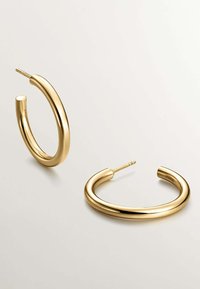 Pendientes de aro de oro con un diseño elegante y redondeado. Presentan un acabado brillante, textura suave y un cierre de poste seguro.
