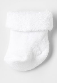 Calzino bianco per bambini piccolo con un polsino testurizzato e soffice, tessuto morbido e corpo a costine. Il design della punta arrotondata aggiunge comfort. Adatto per neonati.