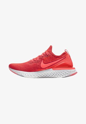 Czerwony dziany but do biegania z koralowym logo Nike, białą teksturowaną podeszwą, wiązaniem na sznurówki i pętelką na pięcie, widok z boku na białym tle.