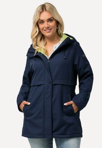 Marinblå vattentät jacka med dragkedja och tryckknappsstängning, justerbar huva med limegrön foder, två sidofickor och en avslappnad passform.