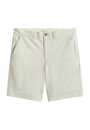 Licht beige katoenen shorts met riemlussen, zijzakken, knoopsluiting en een klein zichtbaar merkembleem aan de binnenkant van de tailleband.