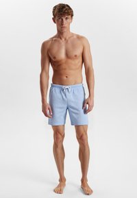 Light blue striped swim shorts with an elastic waistband and drawstring, made of a smooth fabric, and featuring side pockets.