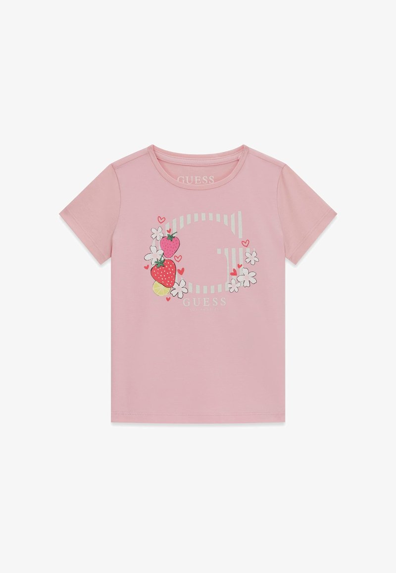 T-shirt rose à manches courtes avec un grand "G" rayé blanc, des fraises, des fleurs blanches, de petits cœurs rouges et le texte "GUESS" sur le devant.