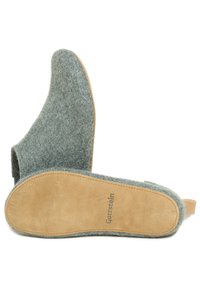 Grå hjemmesko med en beige ruskindssål, der har en rund tå og åben bag, mærket "Gottstein" på sålen.