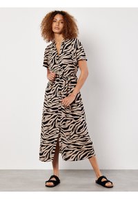 Tiermuster-Midikleid mit beigem Grund und schwarzen Zebra-Streifen, kurzen Ärmeln, tailliertem Gürtel und einem Schlitz vorne.