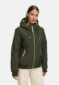 Grön vadderad jacka med huva, framsidan med dragkedja och snörning. Har två fickor med dragkedja på sidorna och ribbade ärmar. Slät textur.