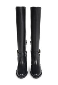 Une paire de bottes en cuir noires hauteur genou avec des zips latéraux et des boucles décoratives près des chevilles, présentées de face.