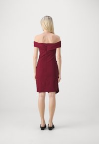 Burgundy off-the-shoulder dress with a fitted bodice, zip closure at back, knee-length hem, and subtle seam detailing.