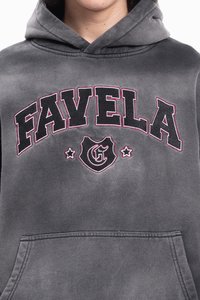 Tumši pelēks kapučis ar uzrakstu "FAVELA" lielos melnos burtos, kuri ir kontūrēti sarkanā krāsā, vairoga emblēma ar "FG" un divām zvaigznēm zem teksta.