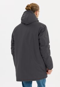Grå vattentät parkas med huva, med en slät yta och en avslappnad passform. Baksidan visar en fåll som når till mitten av låret.