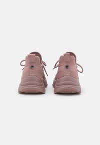 Růžové síťované tenisky s texturovaným designem, šněrováním a výrazným logem vzadu. Silná gumová podrážka se vzorem cikcak.