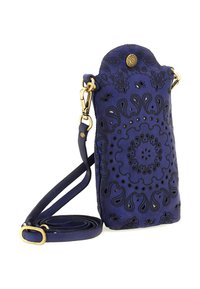 Piccola borsa a tracolla di colore blu navy con motivo paisley nero, hardware in tonalità oro e tracolla regolabile arrotolata accanto su sfondo bianco.