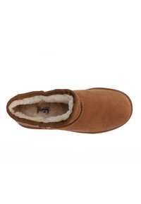 Pantofole in suede marrone con fodera in pelliccia sintetica, forma ergonomica e punta rotonda. La morbida texture aumenta il comfort e il calore.