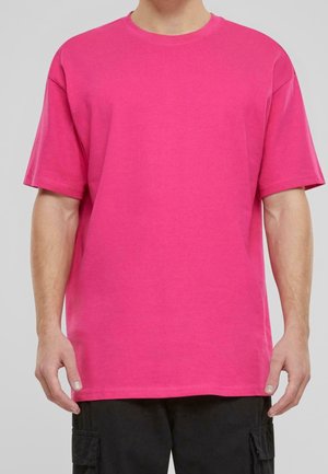 T-shirt en coton rose avec un col rond et des manches courtes. Il présente une coupe décontractée et une texture lisse. Design simple, sans motifs visibles.