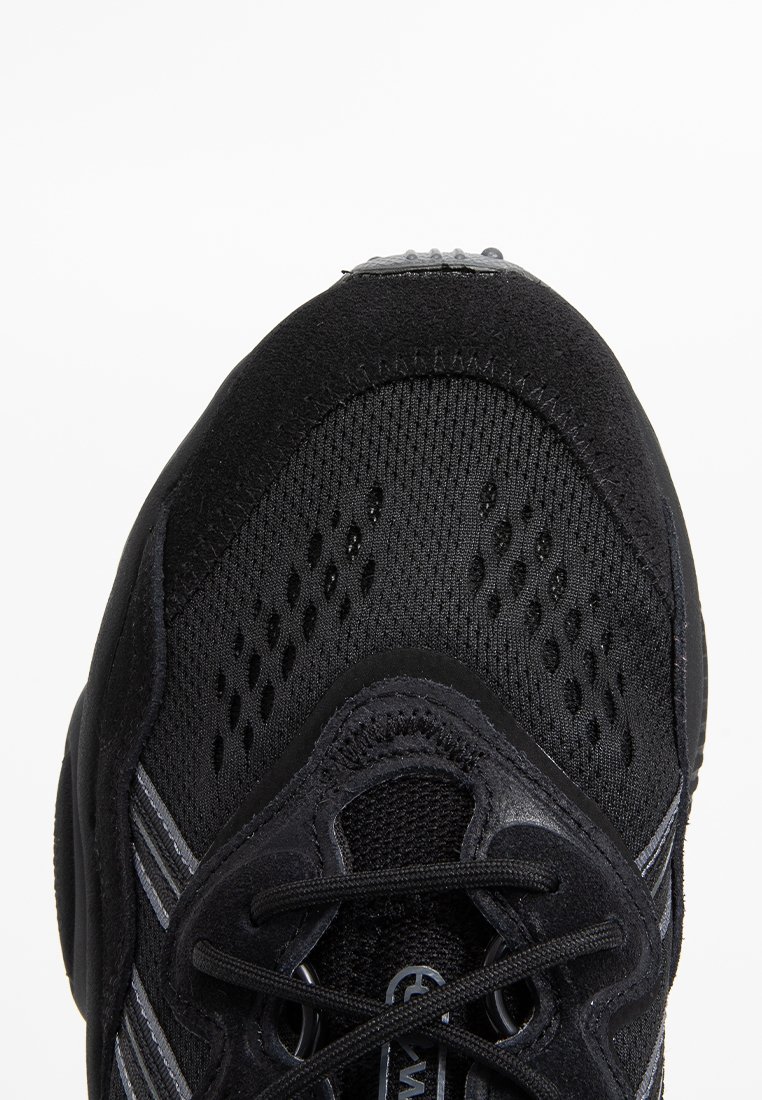 Schwarzer Sportschuh mit Mesh-Obermaterial, synthetischen Akzenten und reflektierenden Streifen. Verfügt über eine runde Zehenpartie und ein strukturiertes Schnürsystem.