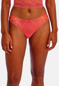 Roze lingerieset bestaande uit doorschijnende mesh stof met florale borduursels, een stippenpatroon en een strikaccent in het midden van de tailleband.