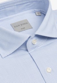 Slank fit skjorte med knapper i lyseblå med et rutemønster. Har en klassisk krave og hvide knapper. Stofoverfladen virker glat.