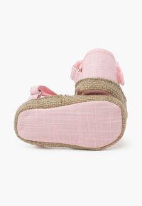 Sandal de tela rosa con suela de yute trenzado, correas ajustables y un acabado texturizado. La suela es plana y ancha para mayor estabilidad.