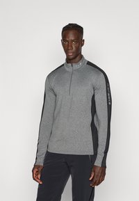 Šedá sportovní mikina na zip s černými bočními akcenty, s vysokým límcem a dlouhými rukávy, vyrobená z texturované, elastické tkaniny.