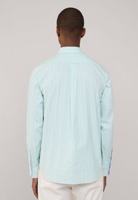 Lichtblauwe shirt met lange mouwen en verticale strepen in roze en paars, met een button-down kraag en een enkele rugplooi. Getailleerde pasvorm.