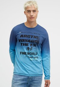 Long-sleeve gradient shirt featuring blue shades, graphic text "ARCTIC VOYAGE TO THE TOP OF THE WORLD," and smooth fabric texture.
