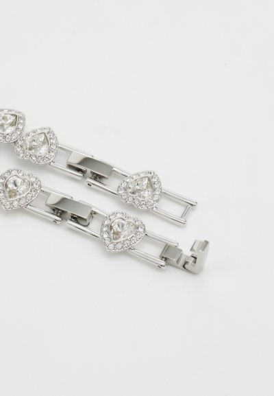Bracelet en argent avec des maillons en forme de cœur ornés de strass transparents, finition en métal lisse et fermeture à clip.