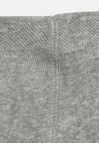 Graue Stricksocken mit einem strukturierten Stoff, glatten Nähten und einem schlichten Design. Das Material wirkt weich und leicht dehnbar.