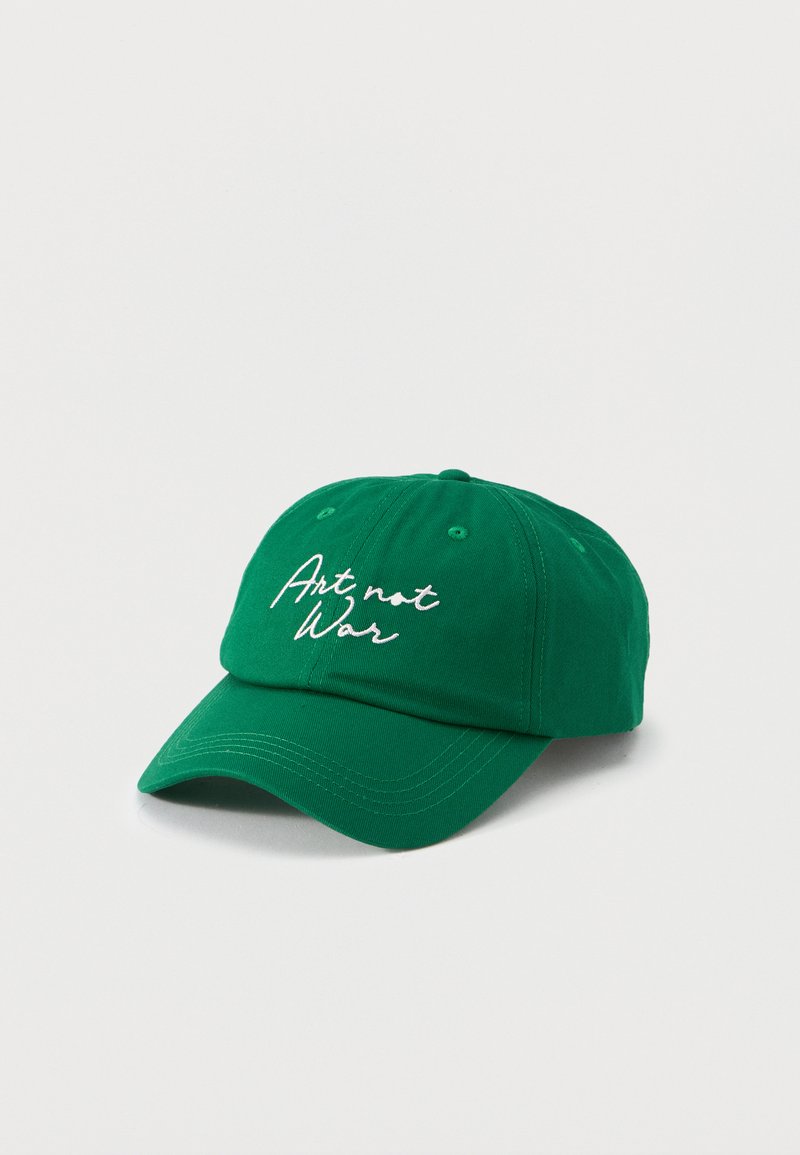 Πράσινο καπέλο μπέιζμπολ με λευκό κεντημένο κείμενο «Art not War» στο μπροστινό μέρος, εμφανίζεται σε απλό ανοιχτό φόντο.