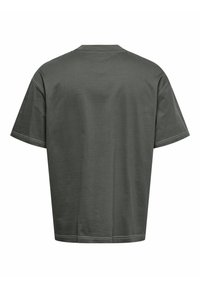 Mørkegrøn bomulds T-shirt med afslappet pasform, korte ærmer og rund halsudskæring. Har kontrasterende hvid syning langs sømmene.