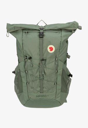 Mochila verde de nylon com um design de fecho superior, bolsos em malha laterais, cordas bungee na frente e um emblema circular da marca.