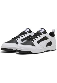 Sorte og hvide sneakers med en glat læderoverdel, perforeret tå, flade snørebånd, polstret krave og sort gummisål.
