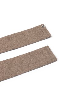 Brown fabric headband, made of soft texture with a smooth finish. Features a small logo tag on one end, with a rectangular shape.
