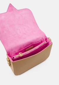 Hnědá kožená taška s růžovým semišovým interiérem. Obsahuje zlatou zipovou kapsu a horní klopu ve tvaru hvězdy. Kompaktní obdélníkový design.