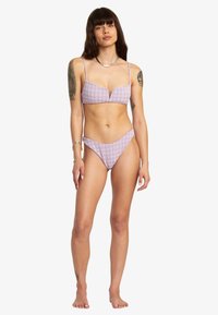 Ensemble de bikini à carreaux en rose et blanc, comprenant un haut rembourré avec des bretelles réglables et un bas de bikini taille basse. Tissu en texture lisse.