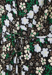 Tessuto nero con un motivo floreale che presenta fiori di colore azzurro chiaro, bianco e verde. Include un dettaglio con cintura legata in vita.