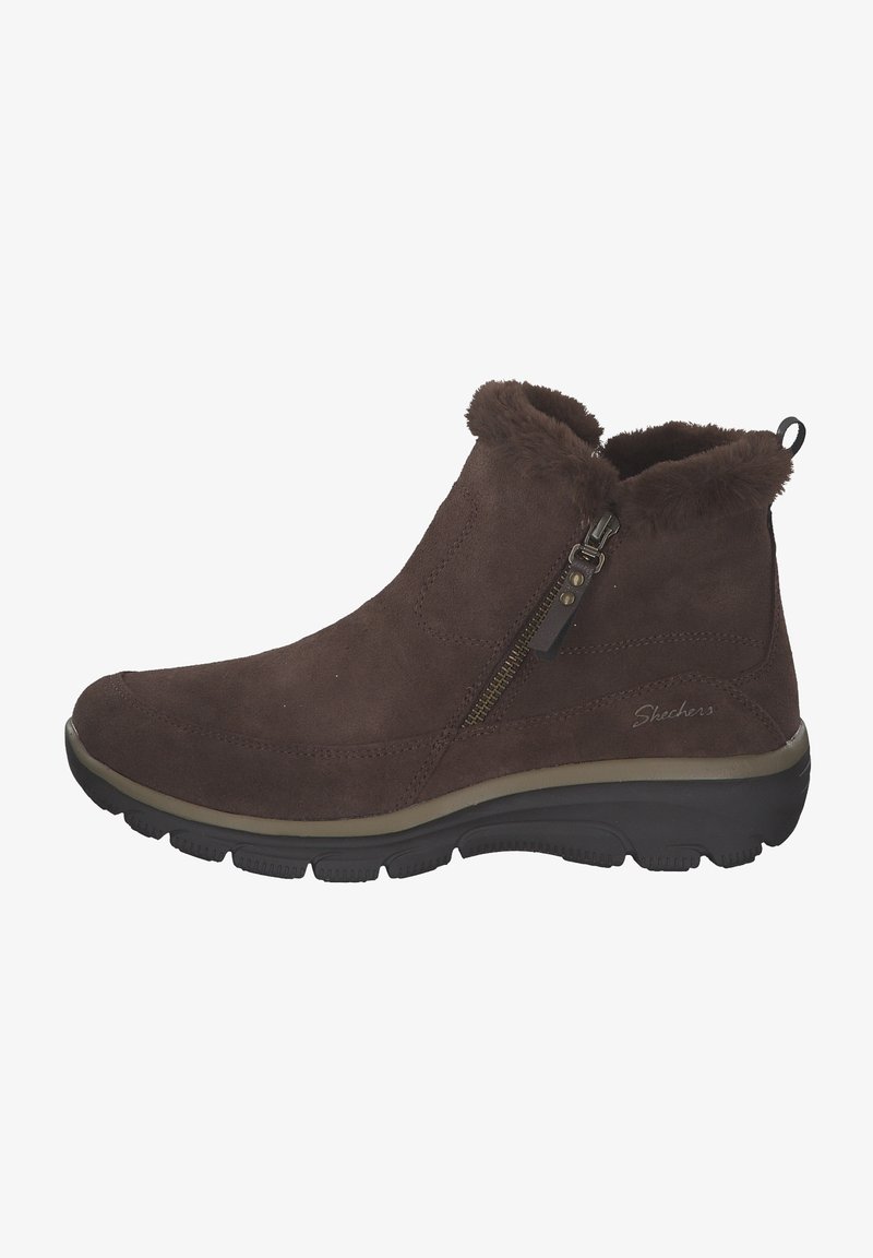 Stivaletti alla caviglia in suede marrone con colletto in pelliccia sintetica, zip laterale e suola in gomma, caratterizzati da una suola chiara a contrasto e un branding sottile.