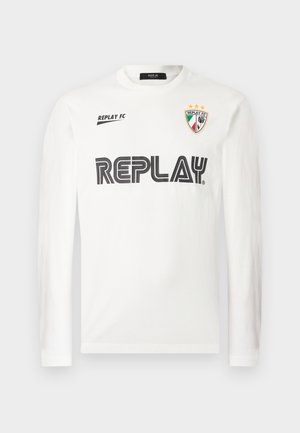 White long-sleeve shirt with black "REPLAY" text across chest, small "REPLAY FC" text on upper left, and a tri-color shield emblem with three stars on upper right.