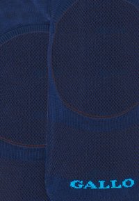 Calze navy con un motivo a maglia testurizzato. Presentano una punta e un tallone rinforzati, con "GALLO" stampato in blu brillante sul lato.