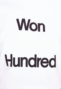 Camiseta blanca con texto en negrita y negro que dice "Ganado" encima de "Cien". Material de algodón con una textura suave y diseño estándar de cuello redondo.