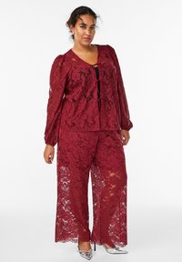 Bordeaux blonde to-delt outfit med en langærmet top med V-hals og bånddetalje, brede bukser, blomsterdesign, gennemsigtig tekstur.