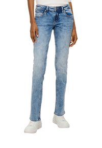Lichtblauwe denim jeans met een slim fit, vijf zakken en lichte slijtplekken. G gedragen met witte sneakers. Eenvormige korrelstructuur.