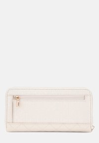 Portefeuille beige clair avec une finition texturée, comportant un compartiment zippé, un motif matelassé en bas et des détails de logo discrets.